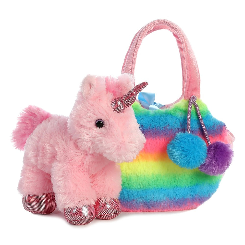 Pink plush unicorn toy next to a rainbow-colored handbag on a white background