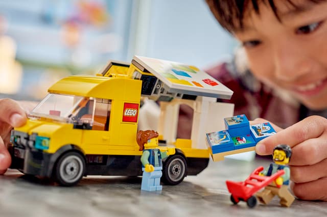 Child playing with a LEGO City Great Vehicles: The LEGO® Van and figures on a table