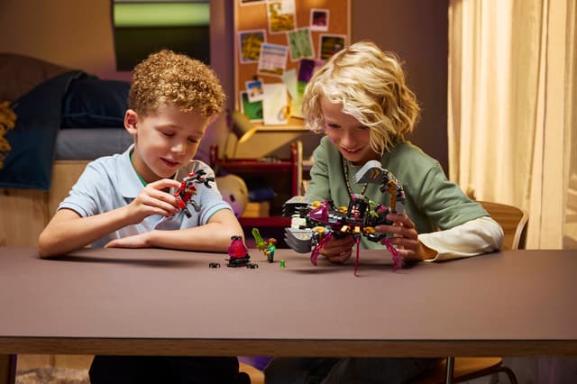 Two children playing with LEGO DREAMZzz: Nightmare Scorpion Digger figures at a table in a room.