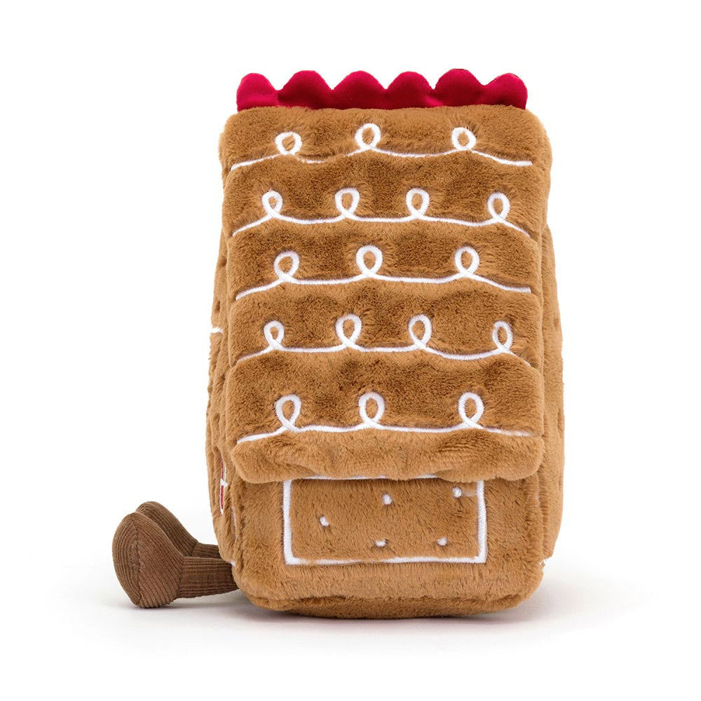 Soft plush toy shaped like a gingerbread house with white icing details and a red scalloped roof, designed as the Amuseables Gingerbread House for imaginative play.