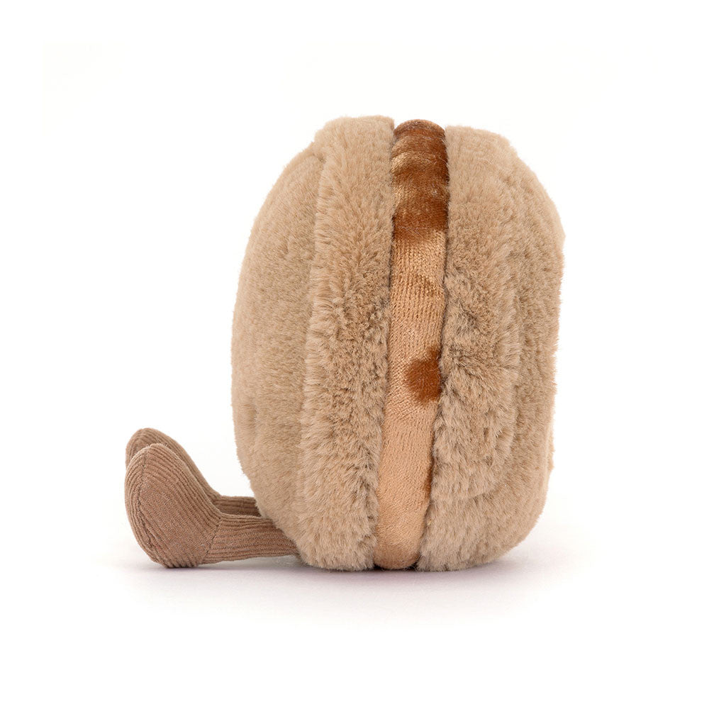 Soft plush toy in light brown resembling a macaron with a brown legs , designed as the Amuseables Mona Macaron for playful collection display.