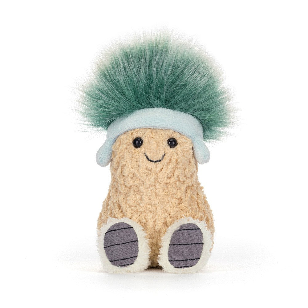 Soft plush toy shaped like a smiling peanut wearing a light blue hat with a fluffy green pompom, known as Amuseables Peanut 'Après Ski'.
