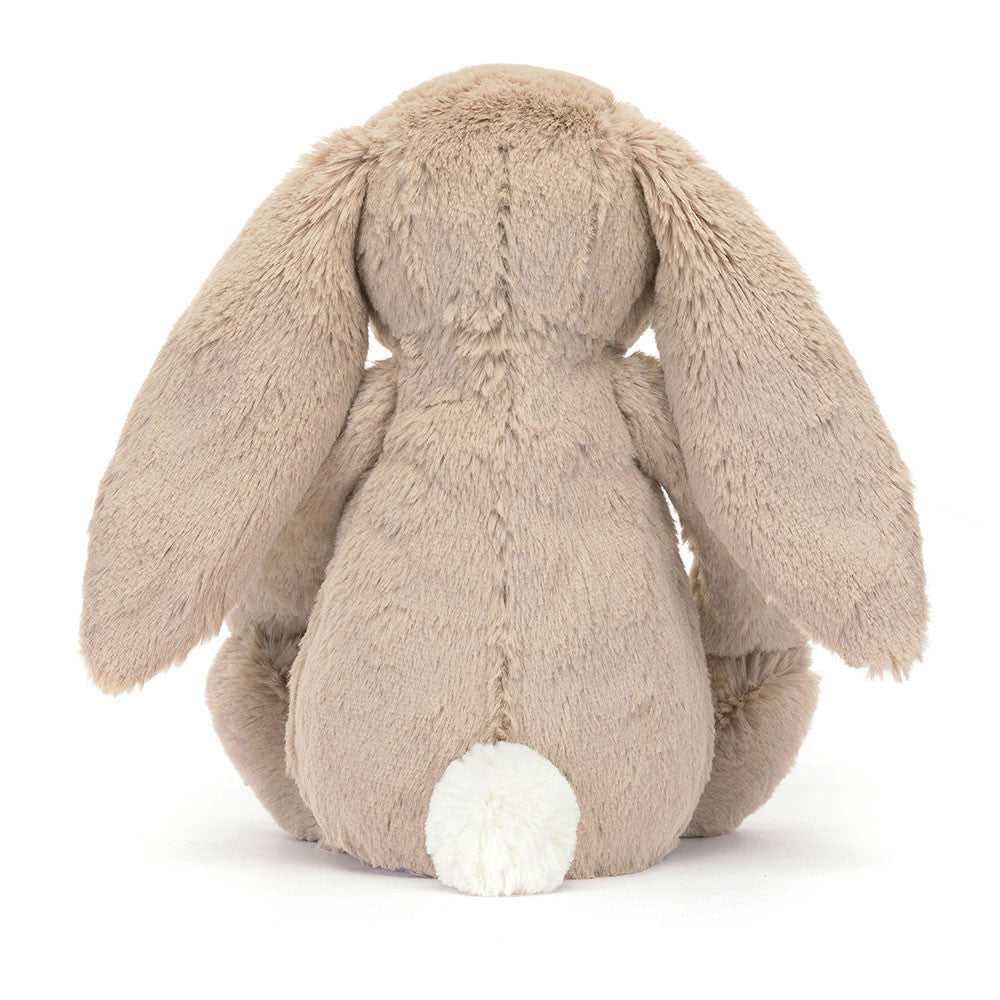 Rear view of a plush Blossom Beige Bunny 'Petal' toy with beige fur and white tail on a white background