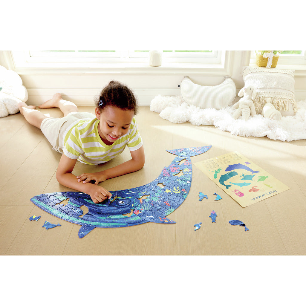 Child playing with a Humpback Whale Shimmer Floor Puzzle - 200pcs on the floor in a bright room.