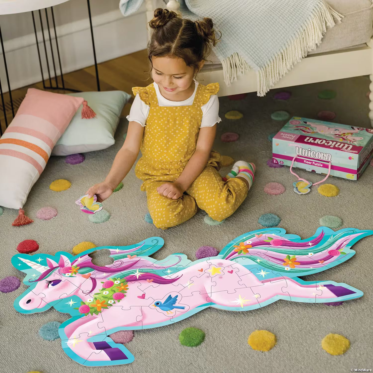 Child playing with a Shimmery Unicorn Floor Puzzle on the floor in a livingroom setting.