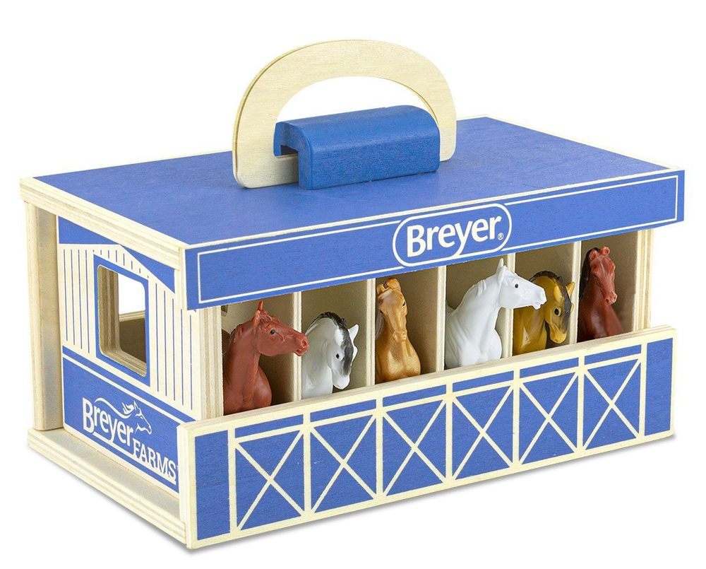 Breyer toy stable with horse figures on a white background