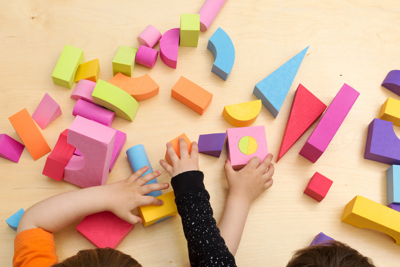 Two children playing with colorful blocks.