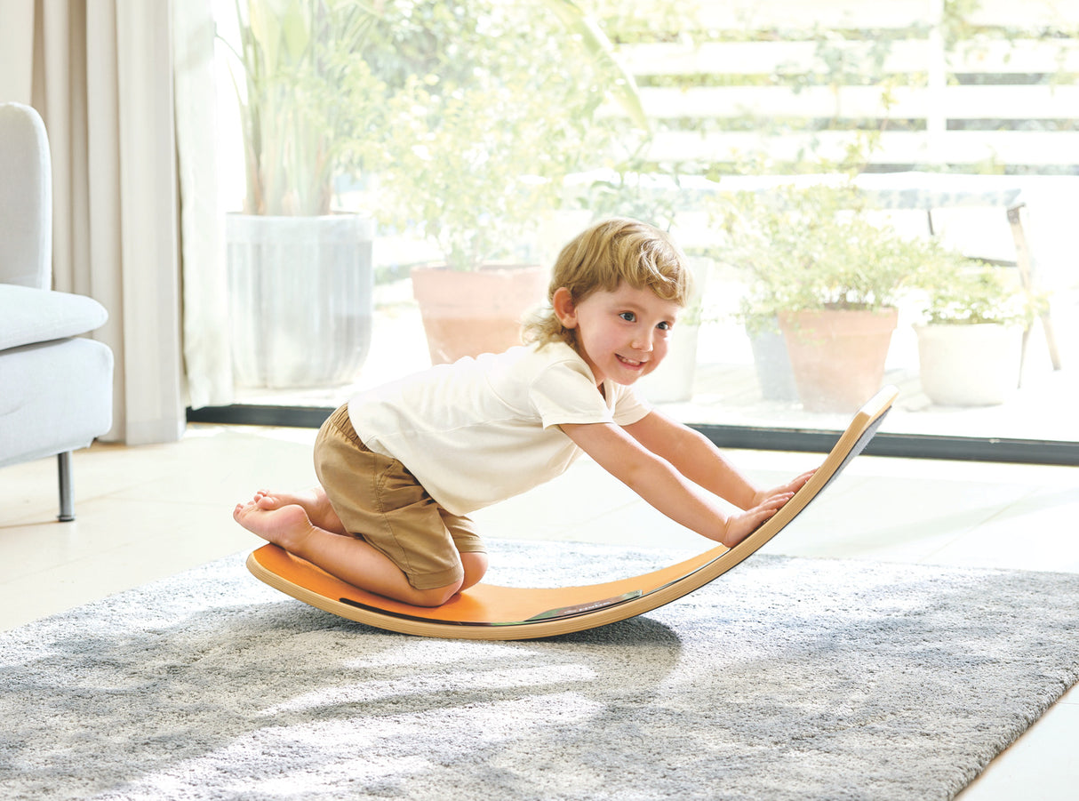 Child playing on a Light-Up Balance Board in a bright living room.