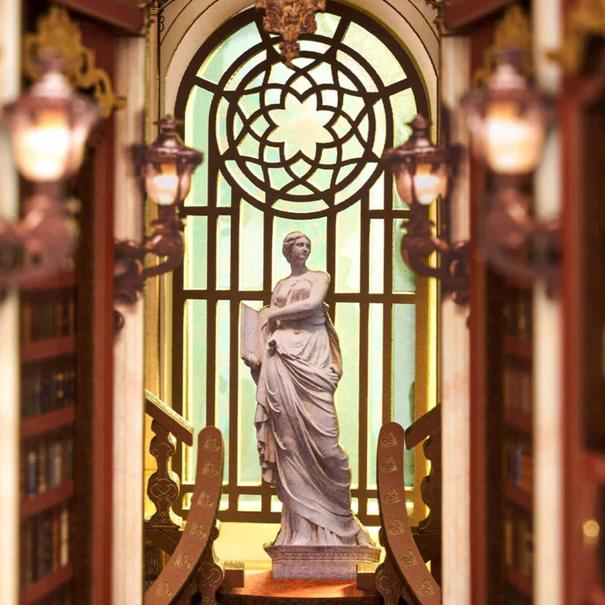 Statue of a woman in a decorative setting with stained glass window included with the Library of Wonders DIY Book Nook kit.