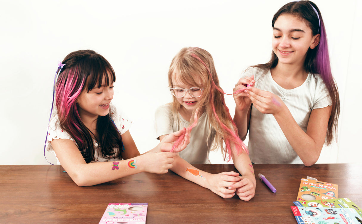 Three children with colorful Hair Doodlers Hair Crayons sitting at a table.