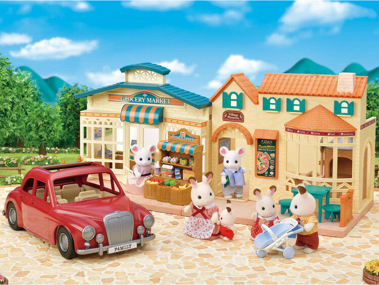 Toy town set with buildings, a Family Cruising Car, and toy figures on a clear day.