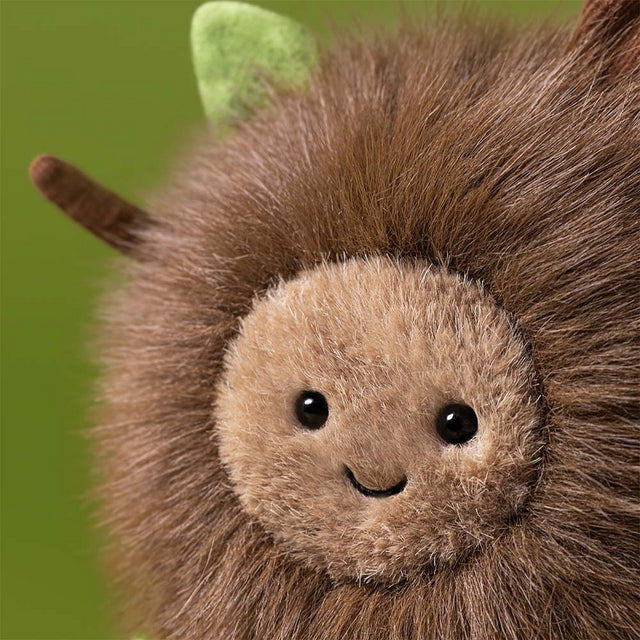 Close-up of a plush toy Amuseables Mulshi Woodland Floor with a green leaf on a green background