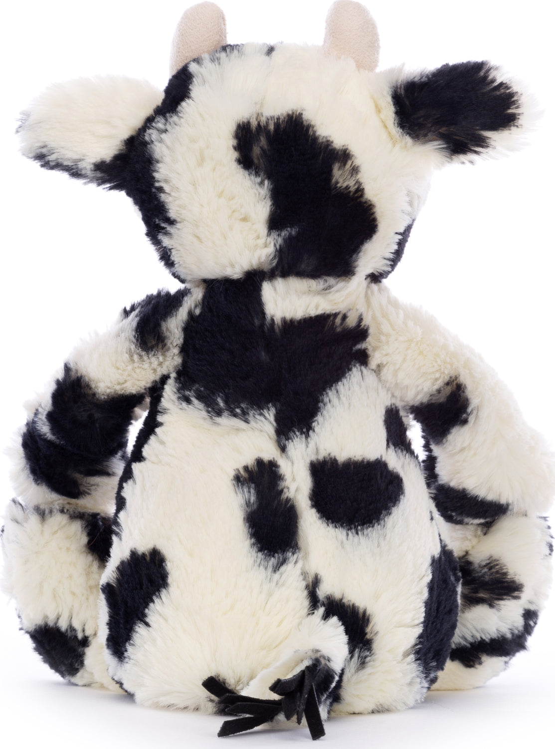 Soft plush toy with black and white spots resembling a cow, featuring small ears and a tufted tail, named Bashful Calf.