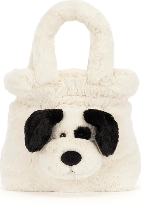 A fluffy faux-fur Rufferty Puppy Handbag shaped like a dog face, featuring black ears, a black nose, and black eye patches on an off-white background, set against a plain white studio backdrop.