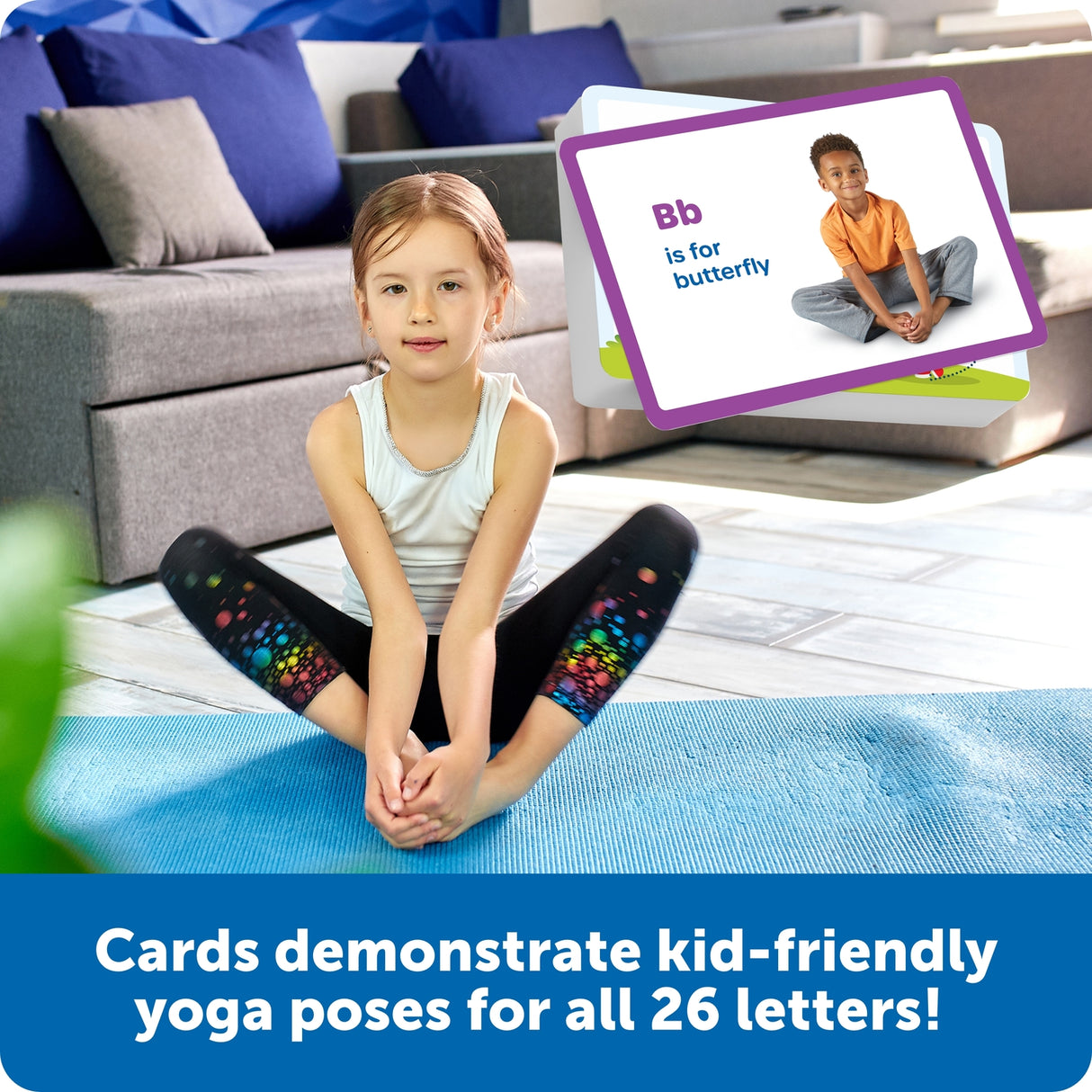 Child sitting on a blue mat with educational cards demonstrating yoga poses for letters, in a living room setting.