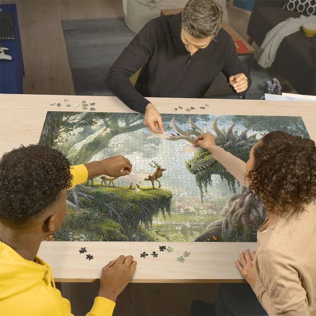 Three people working on a Jigsaw Puzzle The Forest Dragon awakes - 3000 Pieces Puzzle together at a table.