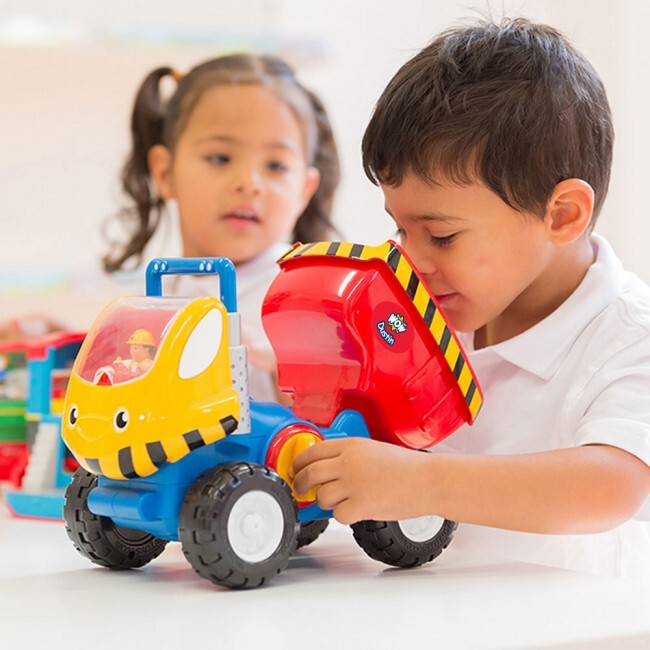 Two children playing with colorful toy Dustin Dump Truck indoors.