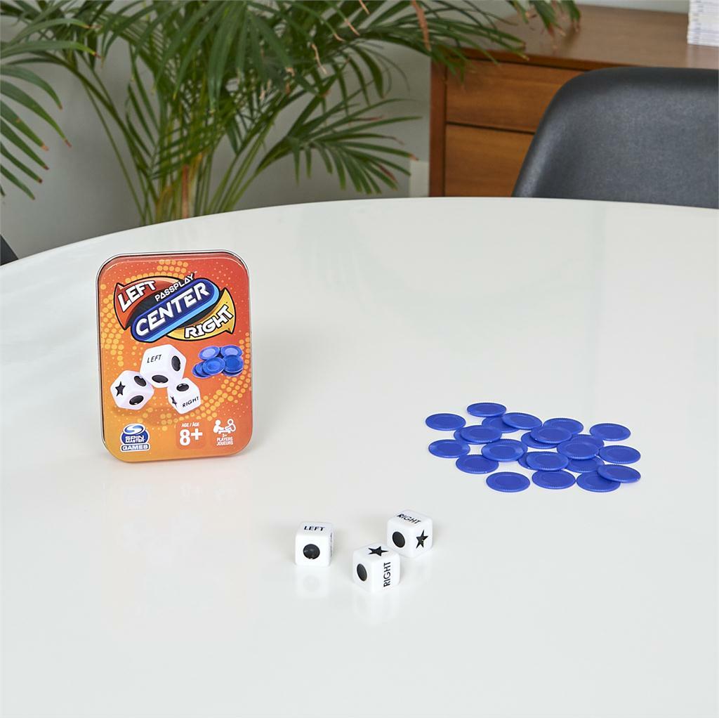 Left Center Right, Tin showing game components including a tin, dice, and blue markers on a table.
