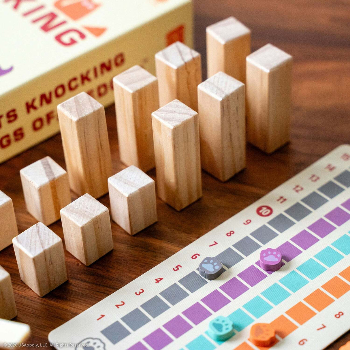Cats Knocking Things Off Ledges Balance Game with wooden blocks and colorful game board on a wooden surface