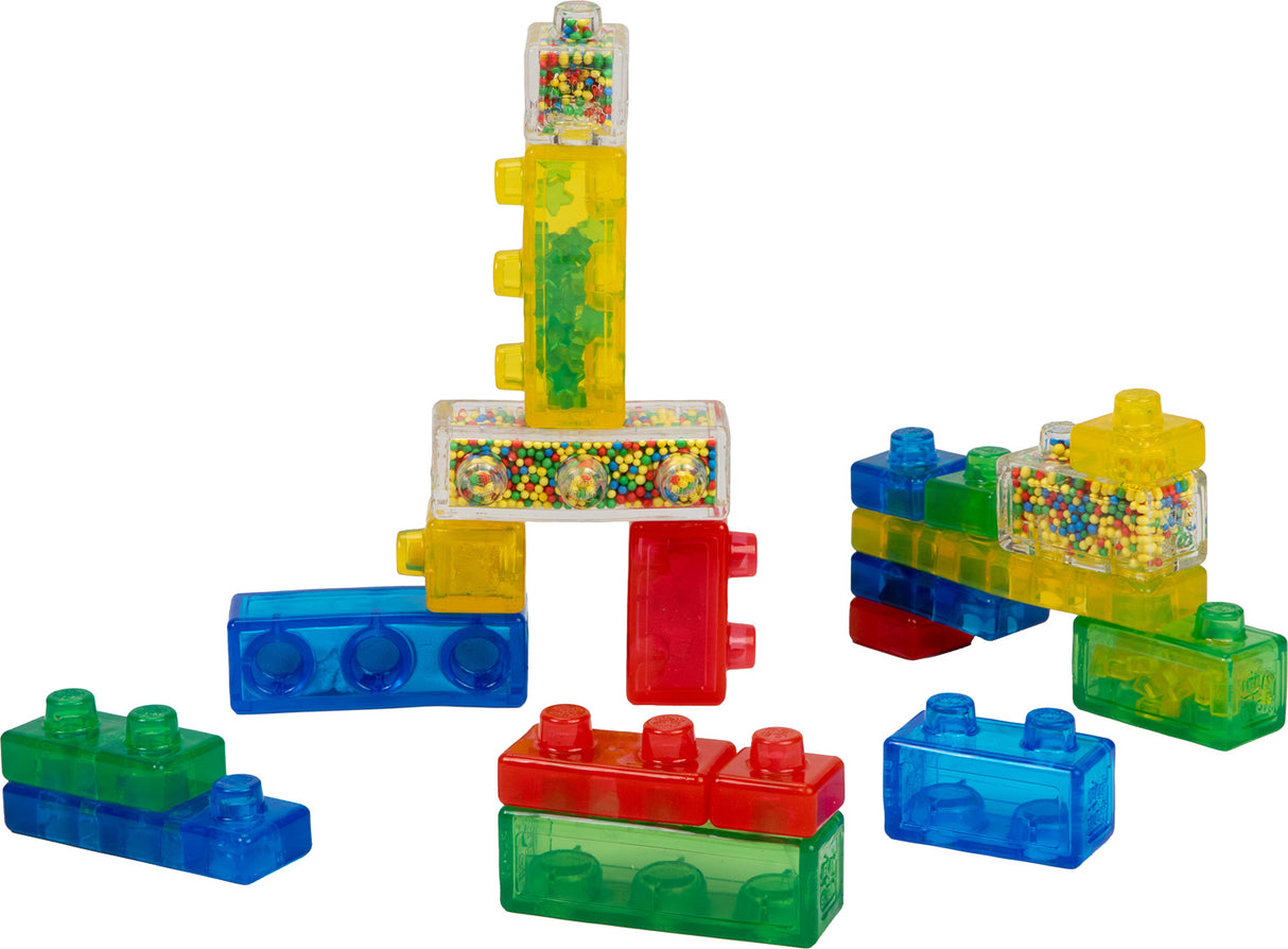 Colorful building blocks with transparent sections filled with multicolored beads on a white background