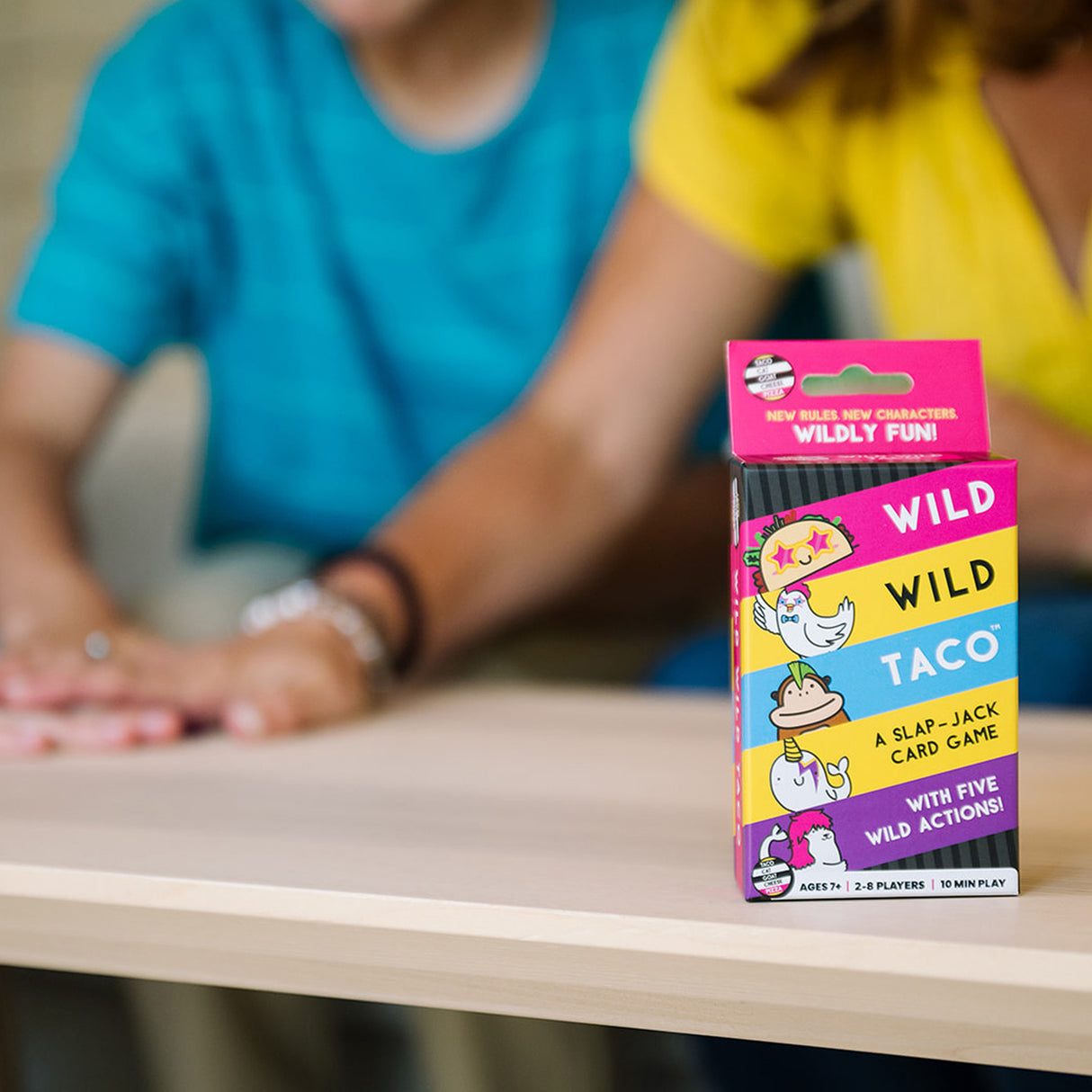 Colorful Wild Wild Taco Card Game box on a table with people in the background