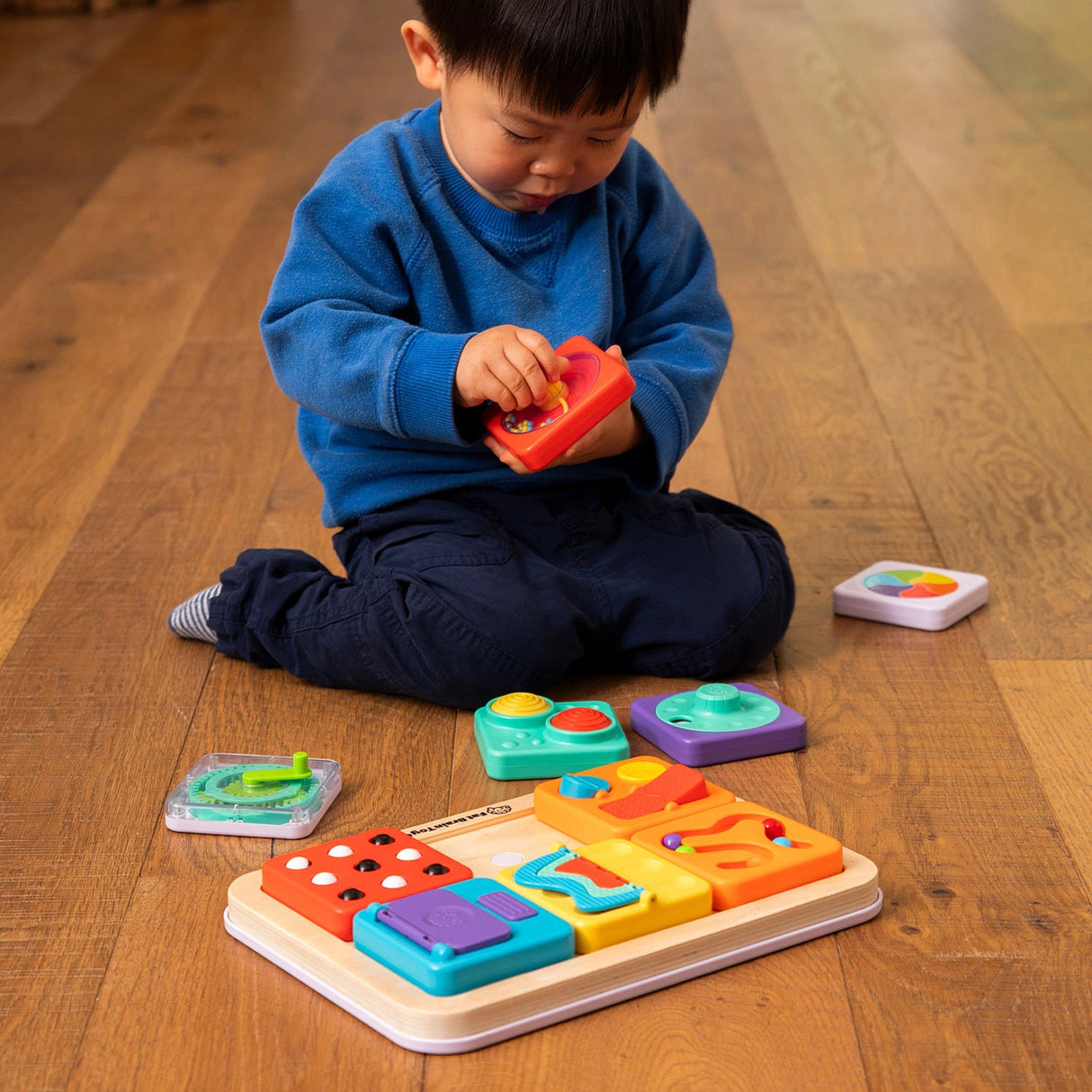 Child playing with a PlayTab - Modular, Sensory, Activity Board on a wooden floor