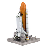 Metal model of Space Shuttle Launch Kit with orange rocket on a white background