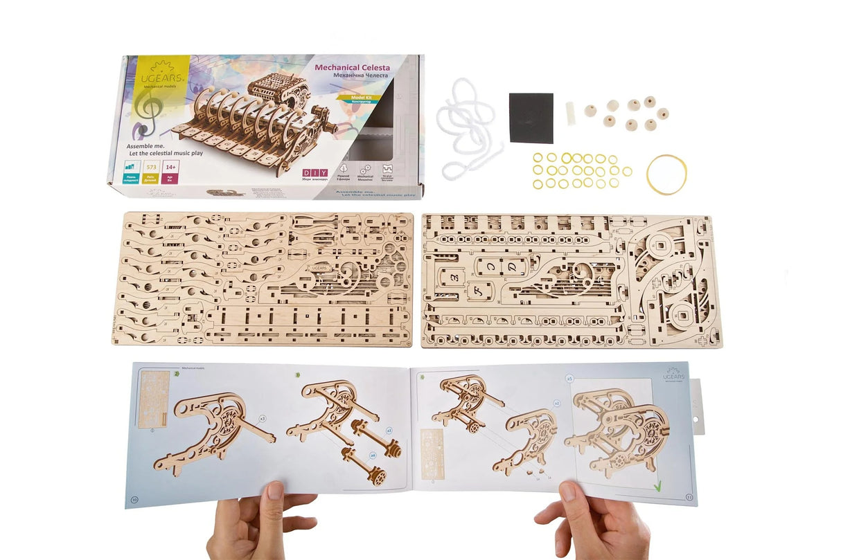 Mechanical model kit with instructions and components on a white background