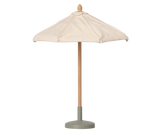 A small Maileg Sunshade, Miniature with a cream fabric canopy, a natural wood pole, and a muted sage green base, shown against a plain white background.