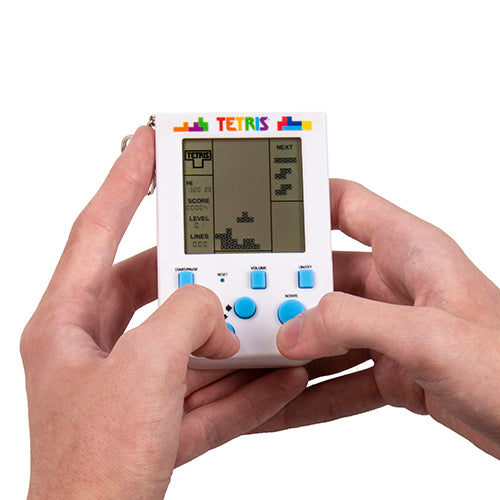 Hand holding a Tetris Keyring Arcade against a white background