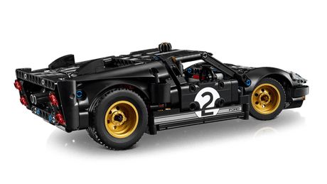 Black LEGO Technic: 1966 Ford GT40 MKII Race Car with yellow wheels on a reflective surface