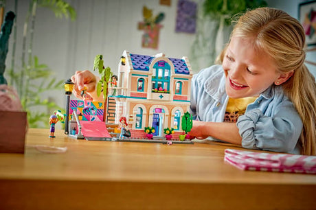 Child playing with aLEGO Friends: Liann's Family House and figures on a table
