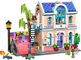 LEGO Friends: Liann's Family House with multiple levels, colorful exterior, and small figures on a transparent background