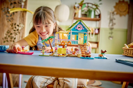 Child playing with a LEGO Friends: Beach House with Seals set on a table