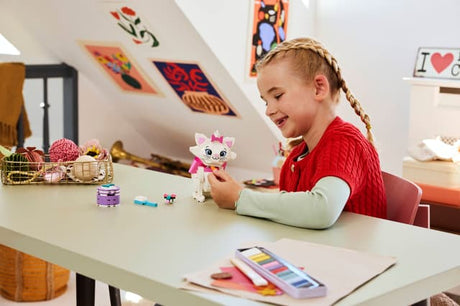Child playing with a LEGO Disney Classic: The Aristocats Adorable Marie at a desk in a room with colorful decorations
