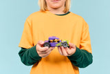 Child holding a LEGO City Great Vehicles: Hot Rod on a blue background