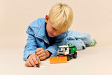 Child playing with LEGO City Great Vehicles: Snowplow on a beige surface