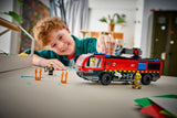 Child playing with a LEGO City Fire: Airport Fire Truck set on a table.