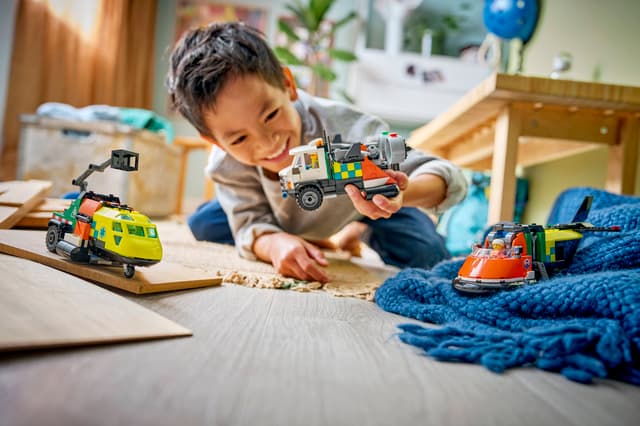 Child playing with LEGO City Great Vehicles: Airplane, Service Truck & Hovercraft Remix on a wooden floor