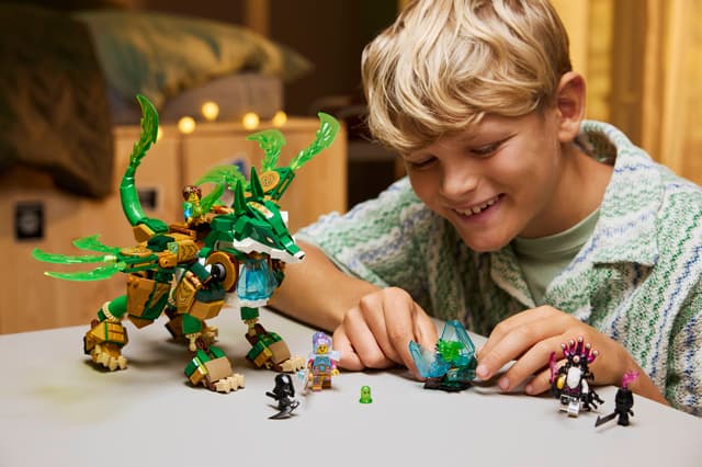 Child playing withLEGO DREAMZzz: Fox Guardian Mech and figures on a table