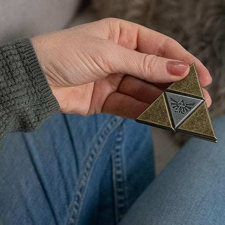 Person holding a Puzzle: Hanayama: Legend of Zelda Triforce Level 5 with a blurred background