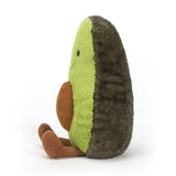 Side view of a plush green Amuseable Avocado Medium toy with brown legs on a white background