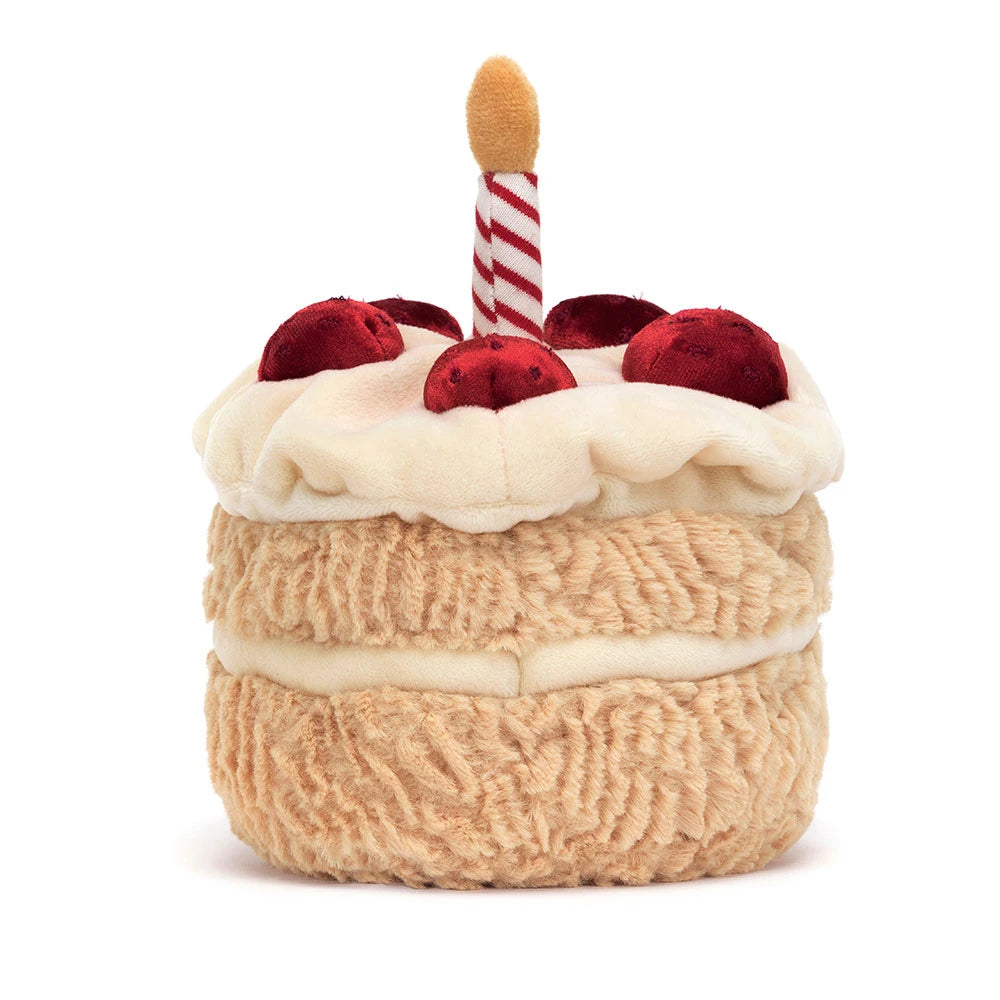 Soft plush toy designed as a small layered cake with white frosting, red cherries, and a striped candle, perfect as an Amuseables Birthday Cake for kids.