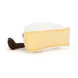 Side view of a plush toy Amuseables Brie wedge of cheese with brown legs on a white background