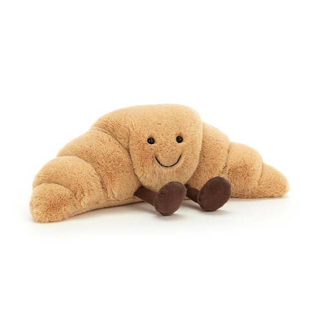 Plush toy Amuseables Croissant with a smiling face and brown legs on a white background
