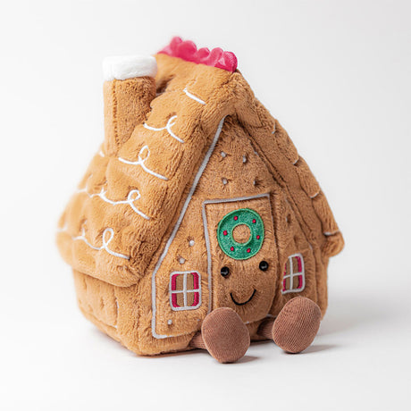 Soft plush Amuseables Gingerbread House with a happy face, decorated with candy details, windows, and a chimney, designed as a cozy children's toy.