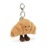 Plush Amuseables Croissant Bag Charm with a smiling face on a white background