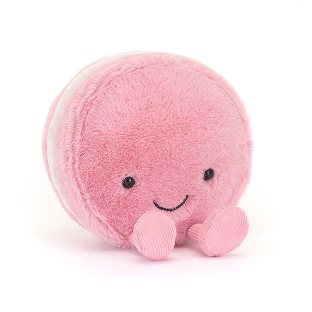 Soft pink plush toy resembling a smiling macaron with small round eyes and two tiny feet, designed as the Amuseables Mia Macaron for children and kids' collections.