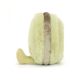 Soft plush toy shaped like a light green macaron with textured fabric and a brown filling, representing the Amuseables Max Macaron.