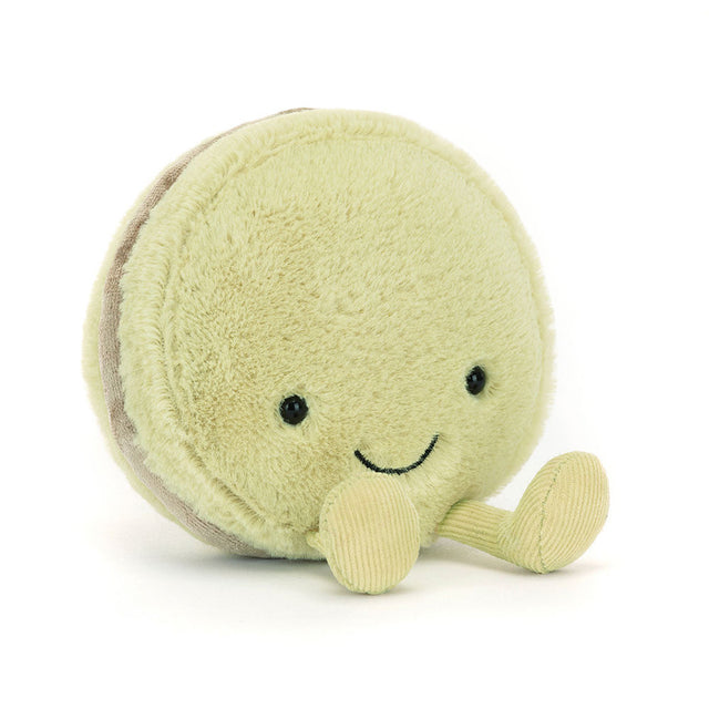 Soft pale green plush toy with black eyes and a smiling face, shaped like a macaron with small corduroy legs, Amuseables Max Macaron design.
